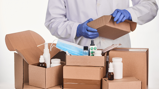 A person in a pair of gloves and white coat opening boxes