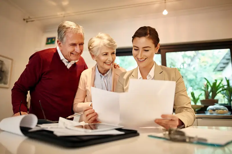 Senior Care Authority Franchise owner happily going over paper work with senior clients
