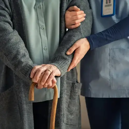 Elderly woman walking with an Assisted Living Facility staff member in Kansas City