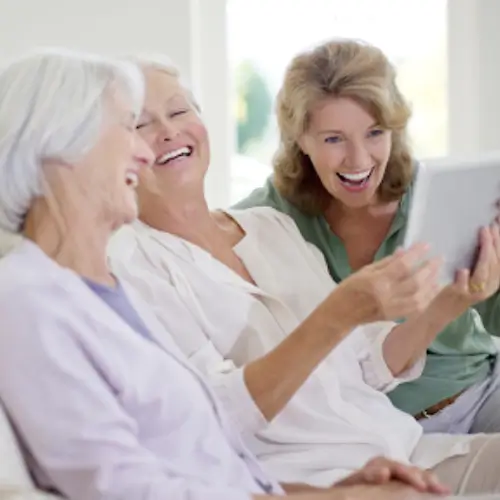 A group of senior women laughing together in an Assisted Living home in San Miguel