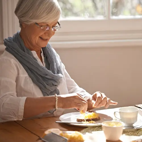 Elderly woman eating breakfast at an Assisted Living facility in River Edge
